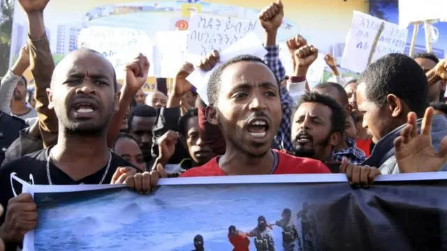 People hold a poster in Addis Ababa on 22 April showing Ethiopians being killed by Islamic State militants in Libya