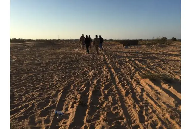 Men walking in sand