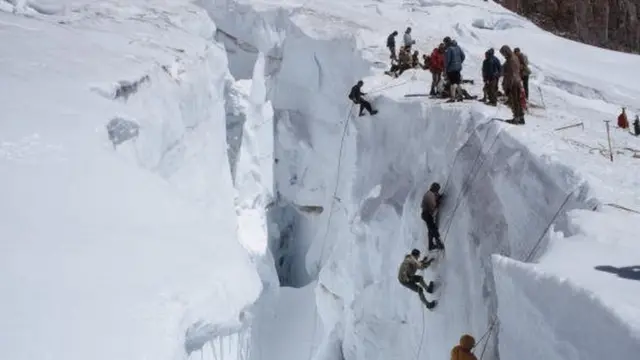 People climbing up an ice-covered mountain