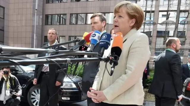 Germany's Chancellor Angela Merkel addresses reporters as she arrives at the European Council headquarters for an extraordinary summit of European leaders to deal with a worsening migration crisis, on April 23, 2015 in Brussels