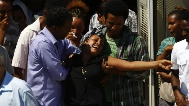 Selemauit Hagus Belay (centre) of Ethiopia cries as a hearse carrying the coffin of her Eritrean husband Ashih Tekleab Haile leaves Mater Dei Hospital outside Valletta, Malta.