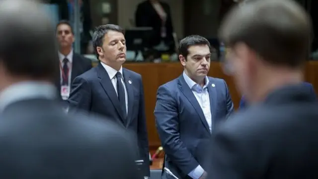 Italian PM Matteo Renzi (left) and Greek PM Alexis Tsipras respect a minute of silence during a European Union extraordinary summit