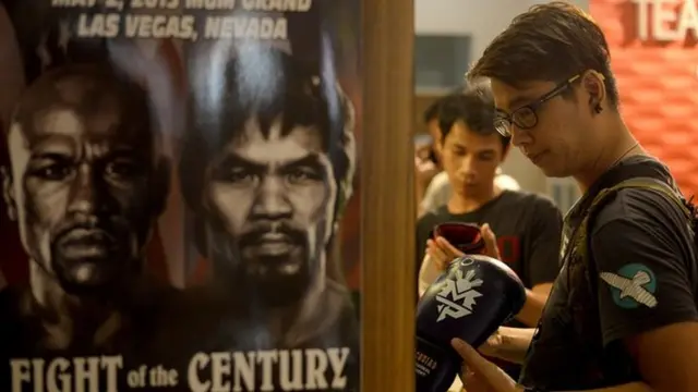 A customer checks boxing gloves signed by Manny Pacquiao on sale at a store in Manila