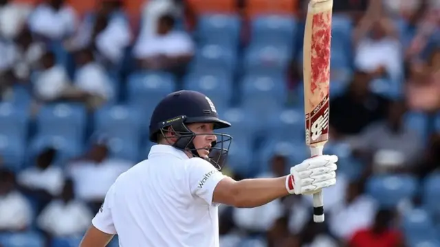 Gary Ballance celebrates by holding his bat aloft