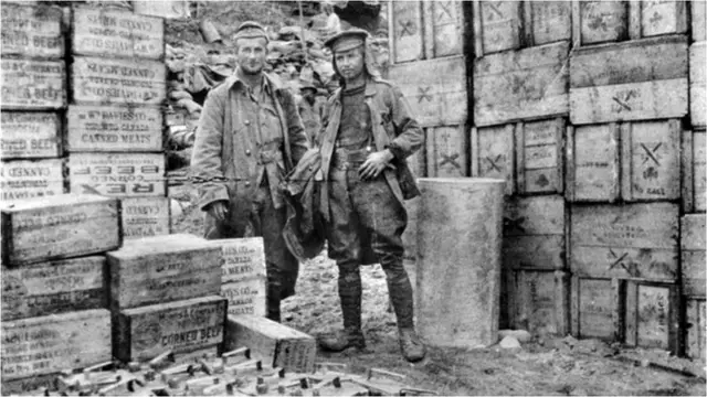 Two soldiers with boxes of corned beef, known as bully beef