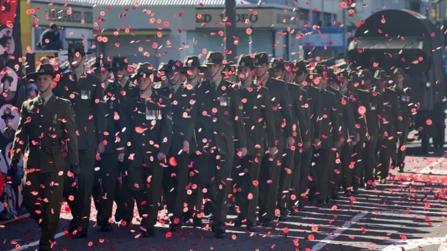 Soldiers march through a sea of poppies during a street parade to commemorate Anzac Day in Wellington, New Zealand