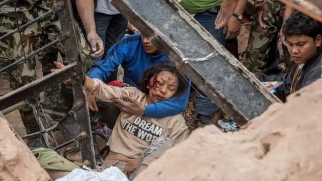 Emergency rescue workers find a survivor in the debris of Dharahara tower after it collapsed in Kathmandu, Nepal