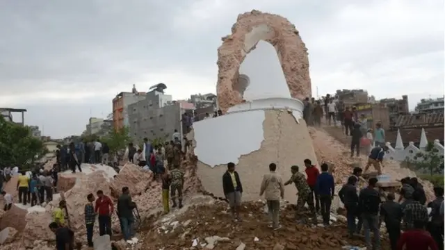 Nepalese rescue members and onlookers gather at the collapsed Darahara Tower in Kathmandu on Saturday