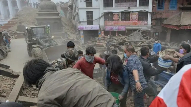 People clear rubble in Kathmandu's Durbar Square, a Unesco World Heritage Site that was severely damaged by Saturday's earthquake in Nepal