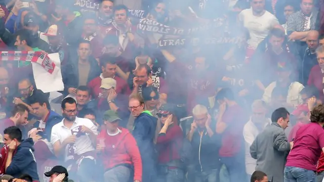 Torino supporters react after a firework explodes