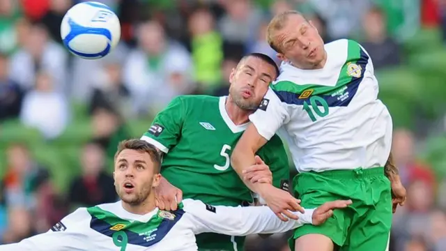 Damien Delaney is sandwiched between Josh McQuoid (left) and Warren Feeney (right) in a match between Republic of Ireland and Northern Ireland in 2011