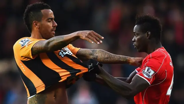 Hull's Tom Huddlestone clashes with Liverpool striker Mario Balotelli