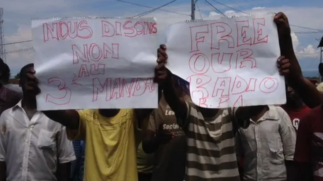 Protesters holding signs calling for radio stations to be reopened