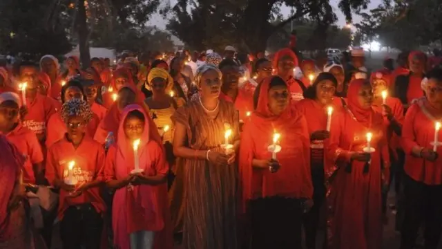 Nigerians holding candles during a vigil for the one year anniversary of the kidnapping of hundreds of Nigerian school girls in Chibok, Abuja, Nigeria, 14 April 2015