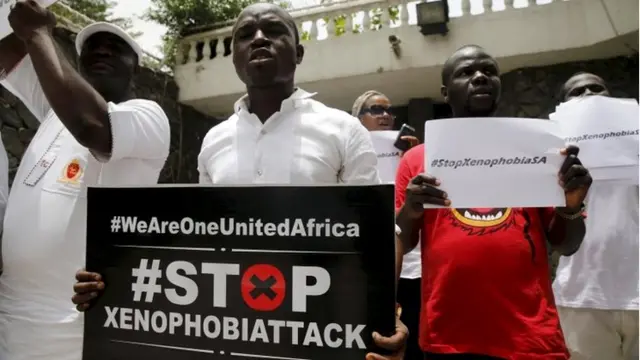 People protesting against xenophobia in South Africa hold placards in front of the South African consulate in Lagos in this April 16