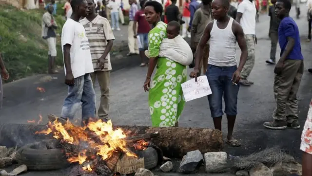 A woman carrying her baby joins demonstrators on a barricade during clashes in Bujumbura, Burundi, 29 April 2015