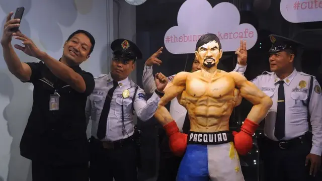 Fans in Manila pose with a $4000 cake of Manny Pacquiao that weighs in at 70kg