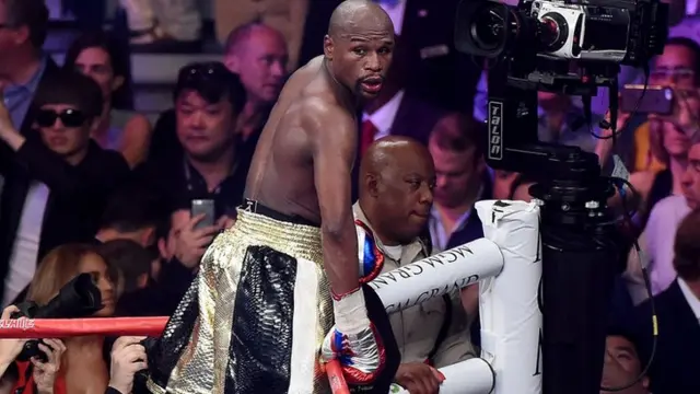 Floyd Mayweather jumps up onto the ropes