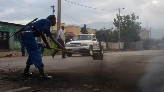 A policeman clears the debris from a barricade in the Bwiza neighbourhood in Bujumbura, Burundi on 5 May 2015