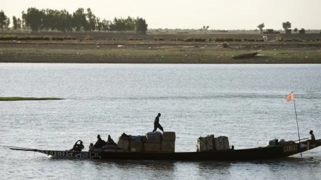 A boat ferries goods down the river Bani, a branch of the river Niger, at the commercial port of Mopti in Mali - 2013