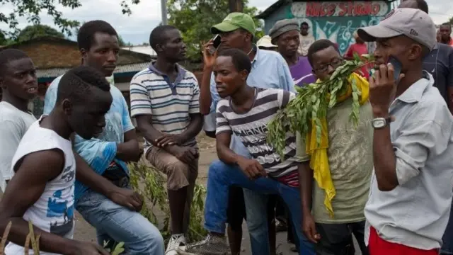 Protesters listen to a the announcement of the constitutional court's ruling on radios at a barricade in the Cibitoke of Bujumbura, Burundi, on May 5, 2015.