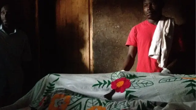 Family by the covered body of a man who died in a grenade attack in Burundi