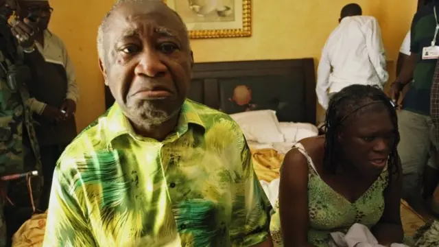 Ivory Coast"s Laurent Gbagbo (L) and his wife Simone sit in a room at Hotel Golf in Abidjan, after they were arrested, in this April 11