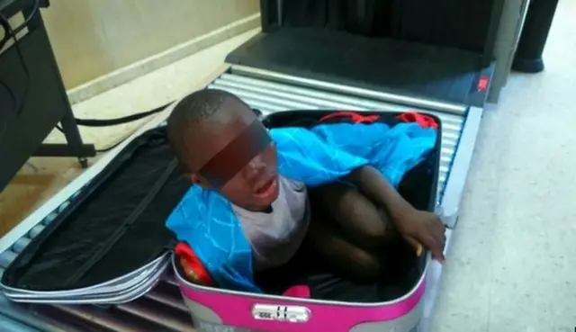 An eight-year-old boy is seen cramped inside a suitcase on a Spanish civil guard border security checkpoint between Morocco and Spain's North African enclave of Ceuta in this handout photo released May 8, 2015.