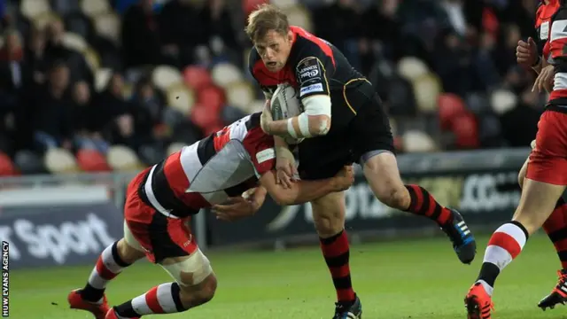 T Rhys Thomas of Dragons is tackled by Stuart McInally of Edinburgh