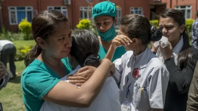 Medics console each other at a Police Hospital in Kathmandu