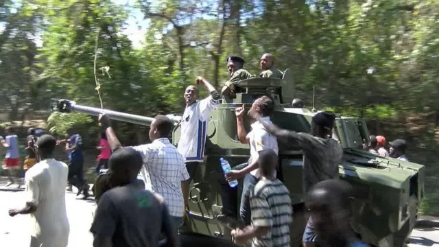 a protester rides on a tank in bujumbura