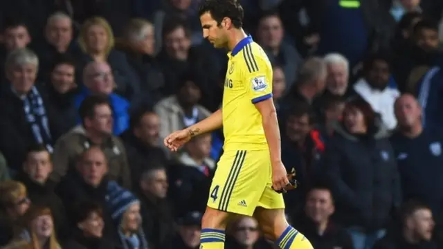 Cesc Fabreags walks off the pitch after being sent off