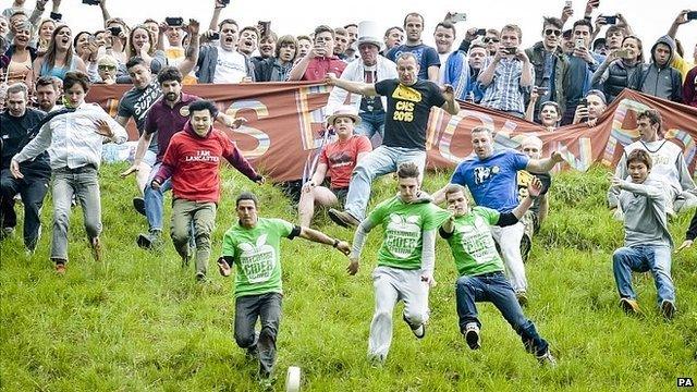 Competitors in the Cheese Rolling on Cooper's Hill race near Brockworth, Gloucestershire