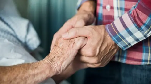 Patient and relative holding hands