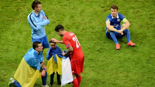 Sevilla's Vitolo comforts a Dnipro player's son