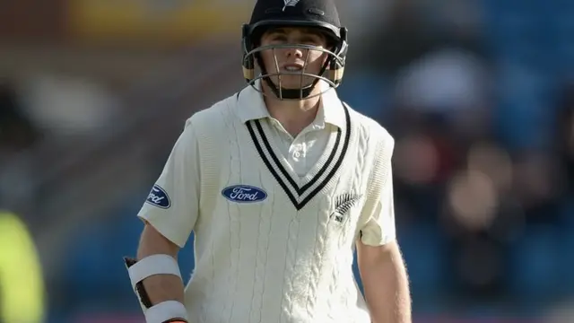 Tom Latham leaves the field after being caught