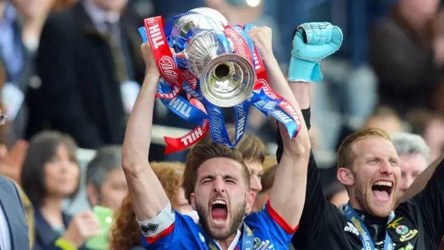 Graeme Shinnie holds the Scottish Cup aloft