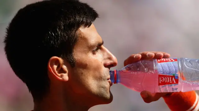 Novak Djokovic takes a drinks break