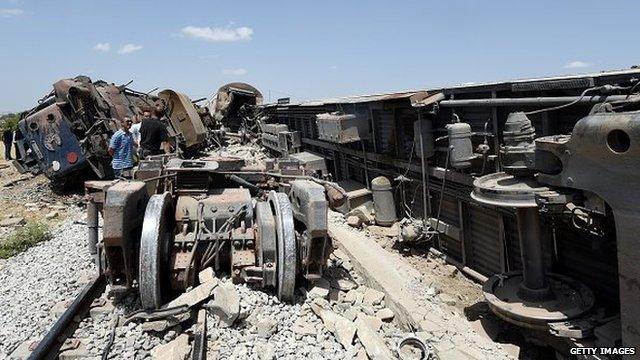 Tunisians surround the carriages of a train after it derailed following a collision with a lorry killing at least 17 people near the town of El Fahes, some 60 kilometres south of the Tunisian capital, Tunis, on June 16, 2015.