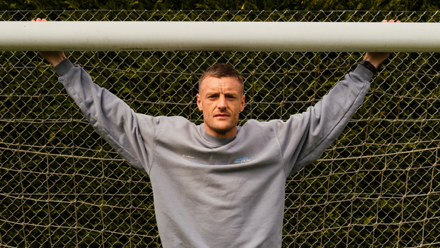 Jamie Vardy stood in a goal with his arms outstretched and holding onto the crossbar