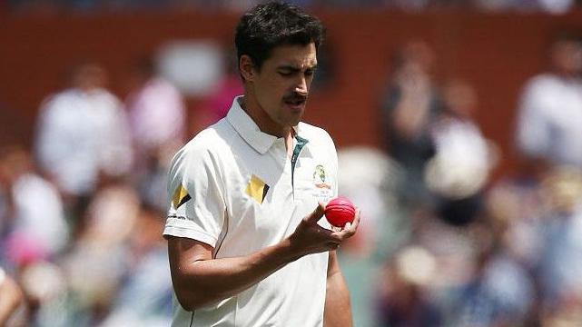 Mitchell Starc inspects the pink ball during Australia's Test against South Africa