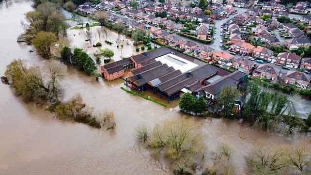 An aerial view of buildings surrounded by floodwater 