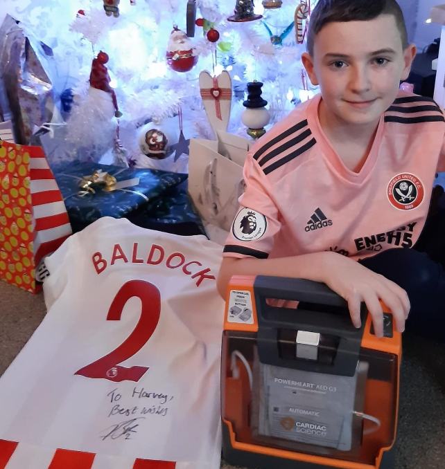 Sheffield United fan Harvey with the defibrillator George Baldock bought him