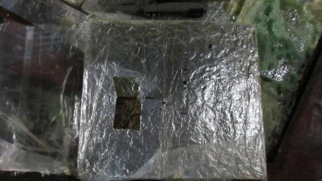 A block of cannabis wrapped up into a square block, border force officials have cut a small square out of the wrapping to expose the cannabis inside.