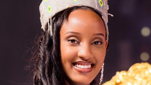 Beauty queen Divine Muheto smiles into the camera, sporting an embellished silver crown and curled hair