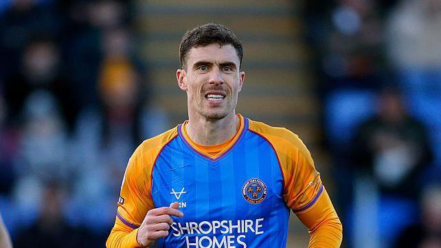 Josh Ruffels wearing a blue and yellow Shrewsbury Town shirt during a game 