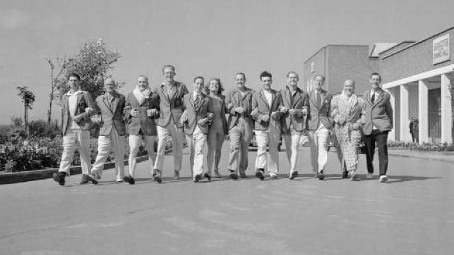 A black and white image showing redcoats walking arm in arm at a Butlin's resort in the 1940s.