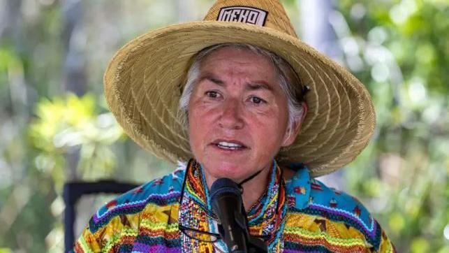 Betty Osceola wearing a straw hat and colourful shirt