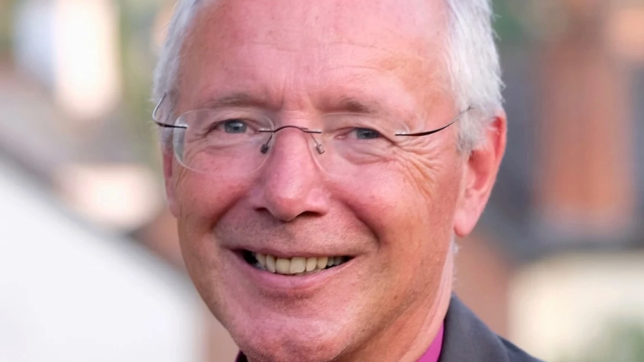 This picture shows a close-up of former Bishop of Plymouth Nick McKinnel, with short, light-coloured hair and glasses, smiling. 