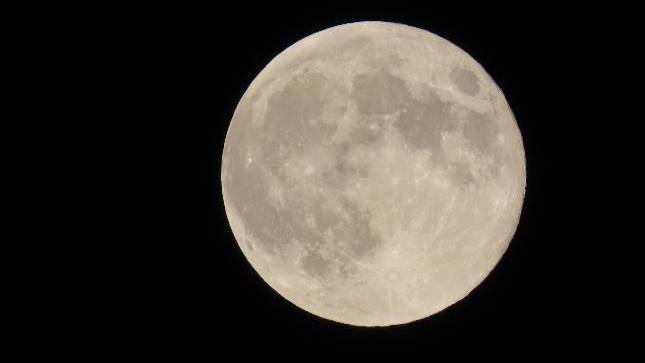 A large moon against a black sky